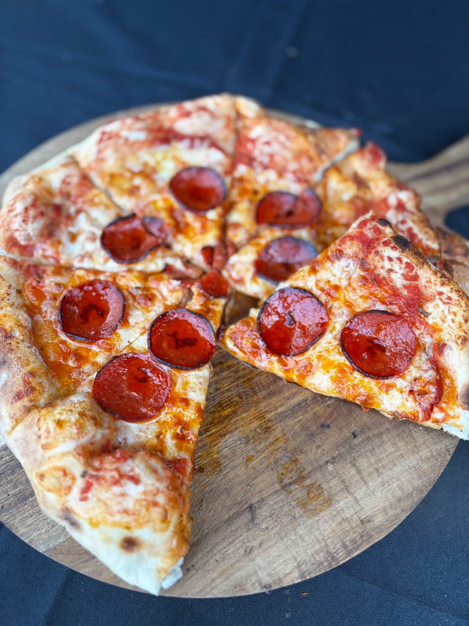 Xanders freshly cooked pizza on a serving board