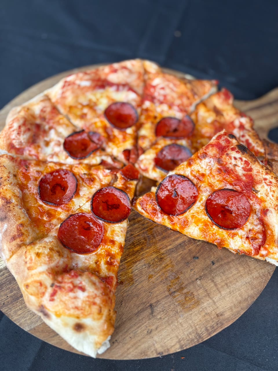 Xanders freshly cooked pizza on a serving board